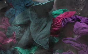 Vêtements violets et vert foncé s’essorant dans une laveuse