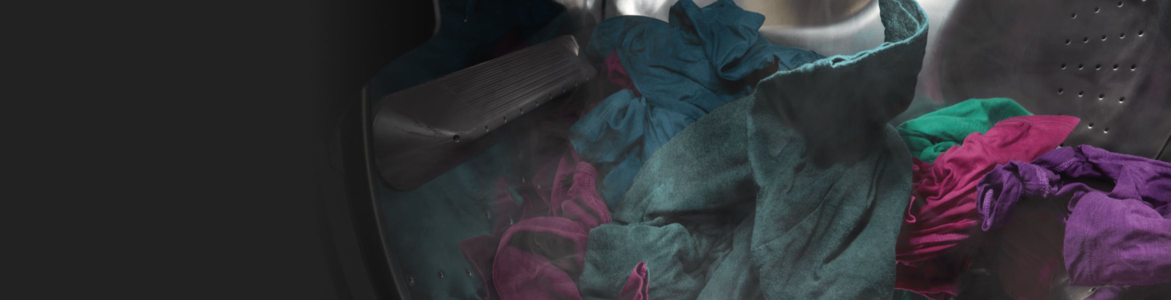 Dark purple and green clothes spinning in a washer