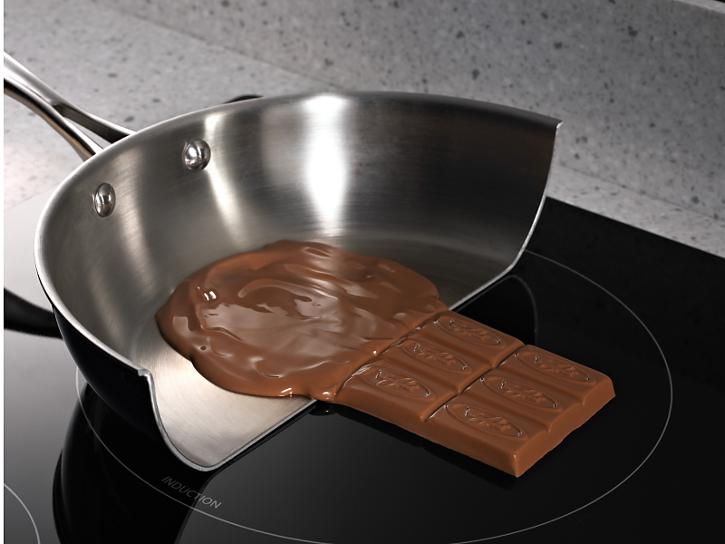 Melted chocolate in a pan on a glass cooktop