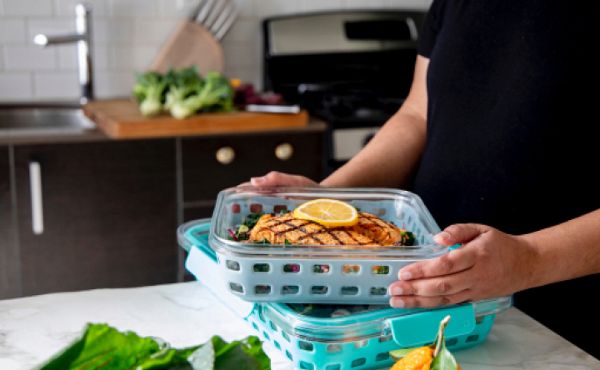 Hand stacking containers with prepped meals