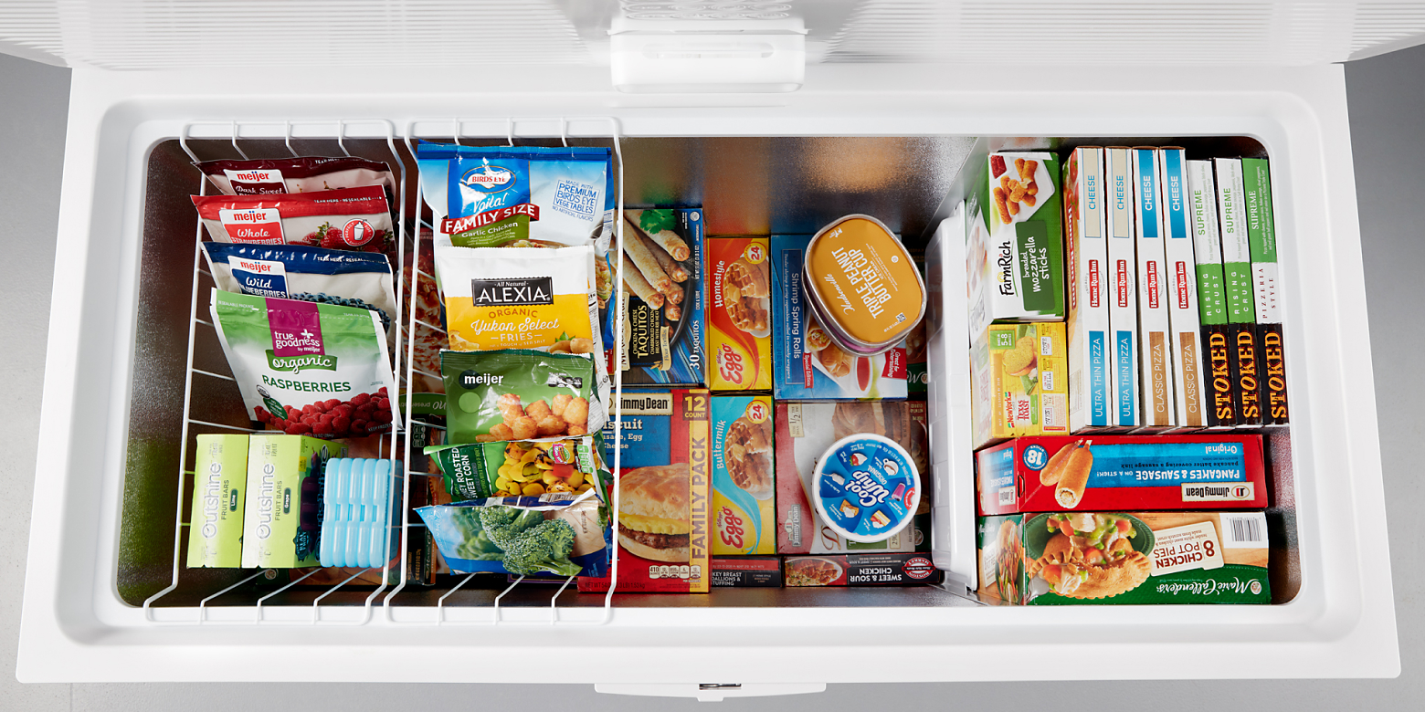 Overhead view of open chest freezer with items organized in freezer baskets