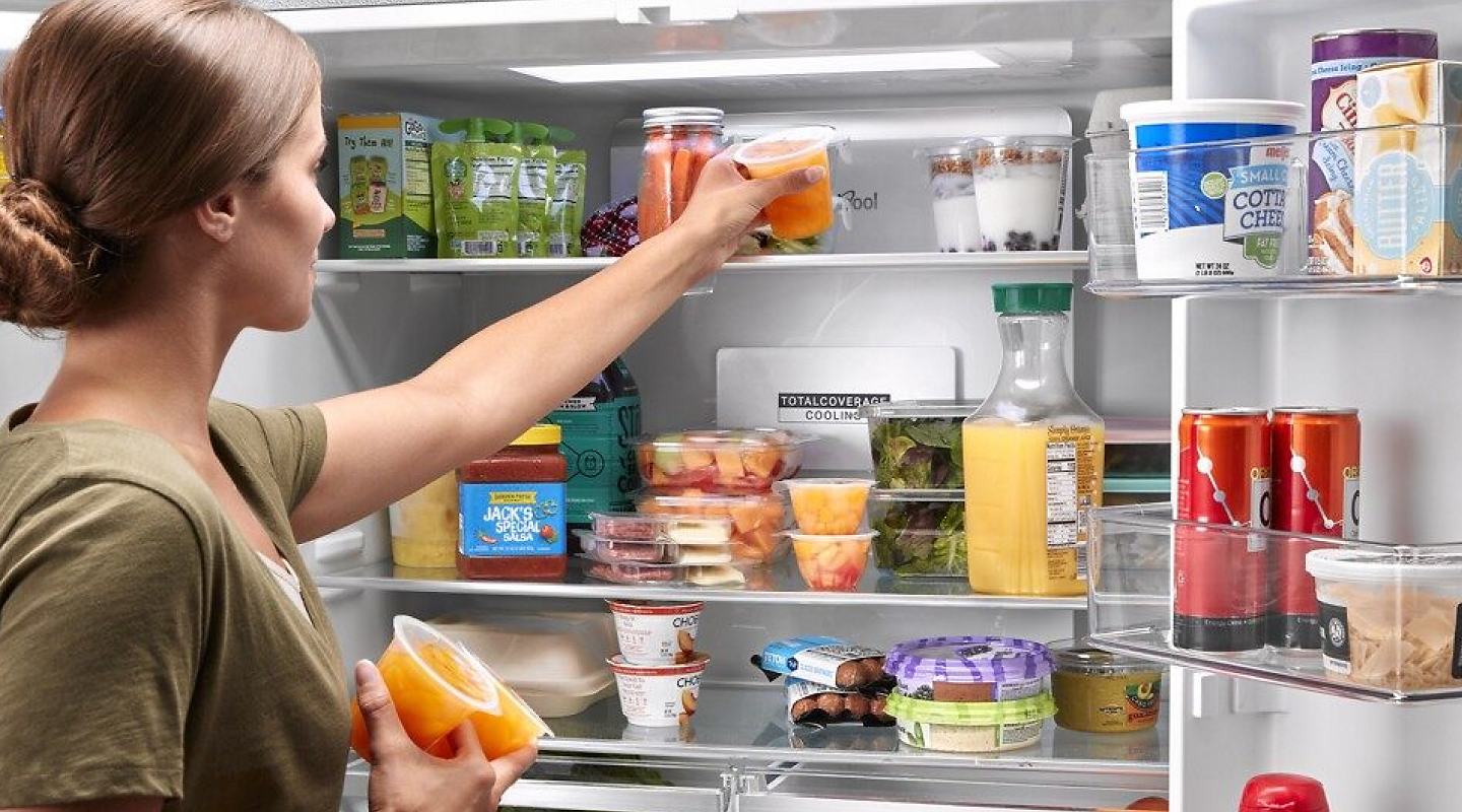 Woman taking food out of a refrigerator