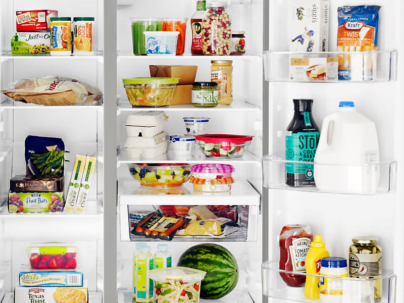 A closeup of the interior of a Whirlpool® side-by-side refrigerator with food and beverage items
