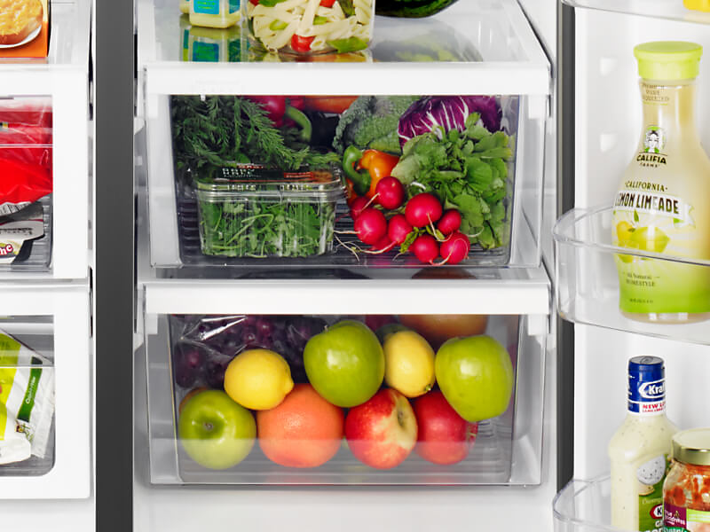 Fresh fruits and vegetables stored in a fridge crisper drawer