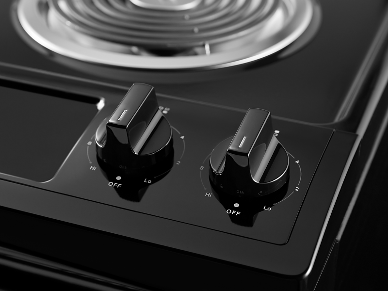 A closeup of the burner control knobs on a Whirlpool® electric range.