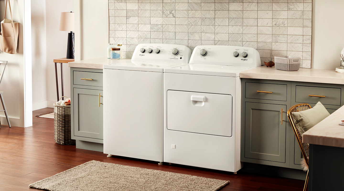 White Whirlpool® washer and dryer pair in gray-brown cabinetry