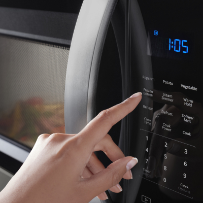 Person selecting a cooking preset on a Whirlpool® microwave