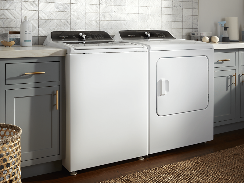 A white Whirlpool® washer and dryer pair in a modern laundry room