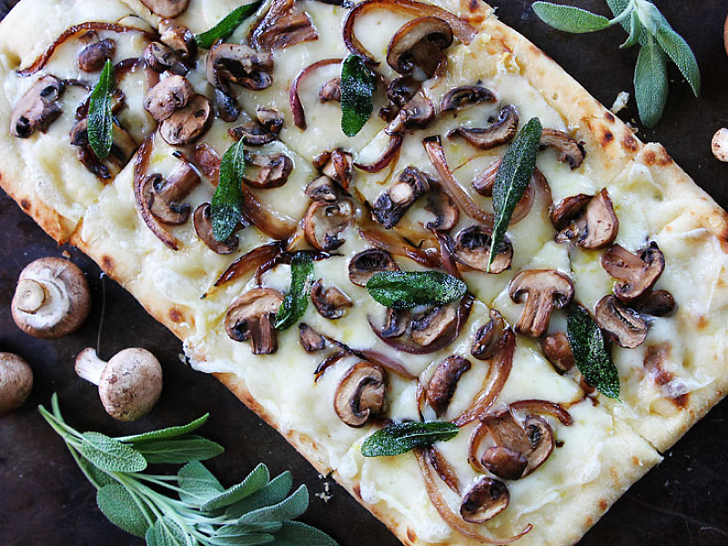 披萨饼上面有奶酪、蘑菇和香草