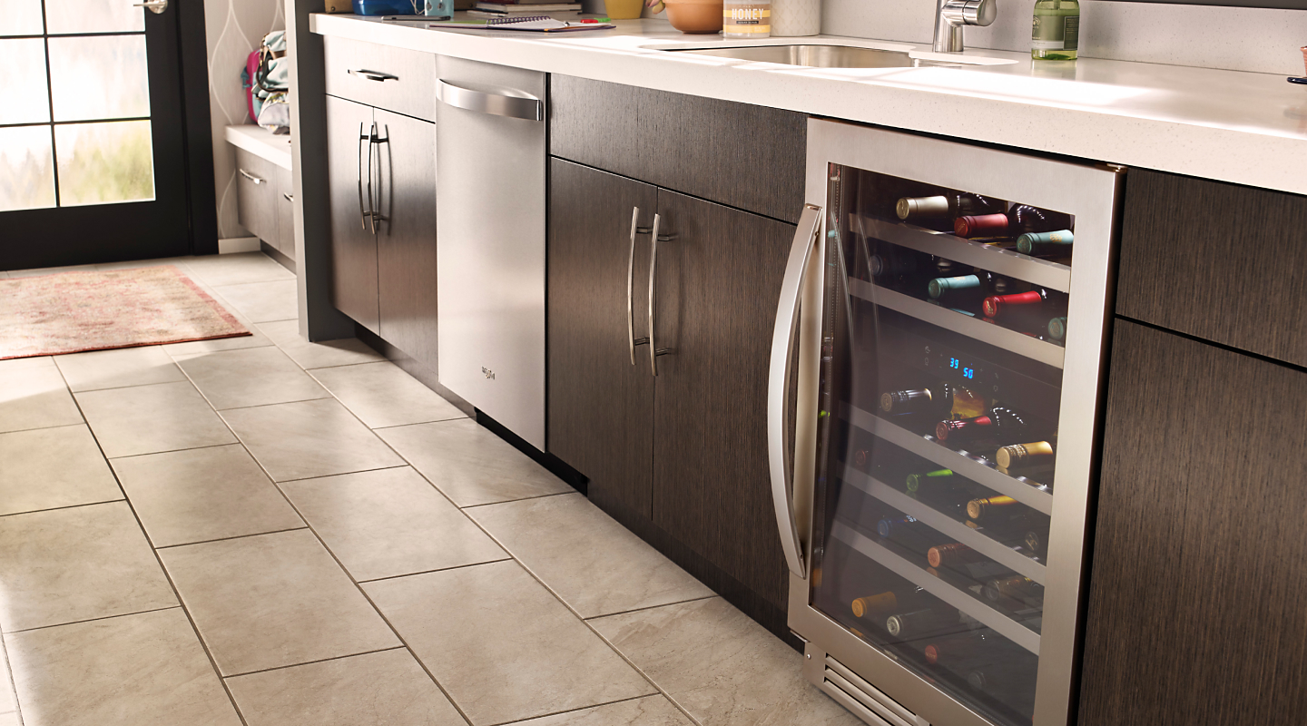 A stainless steel wine fridge in a modern kitchen with different appliances