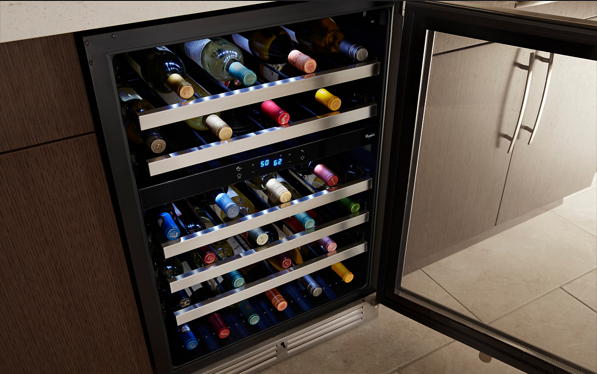 Wine bottles stored on the various levels of a wine fridge