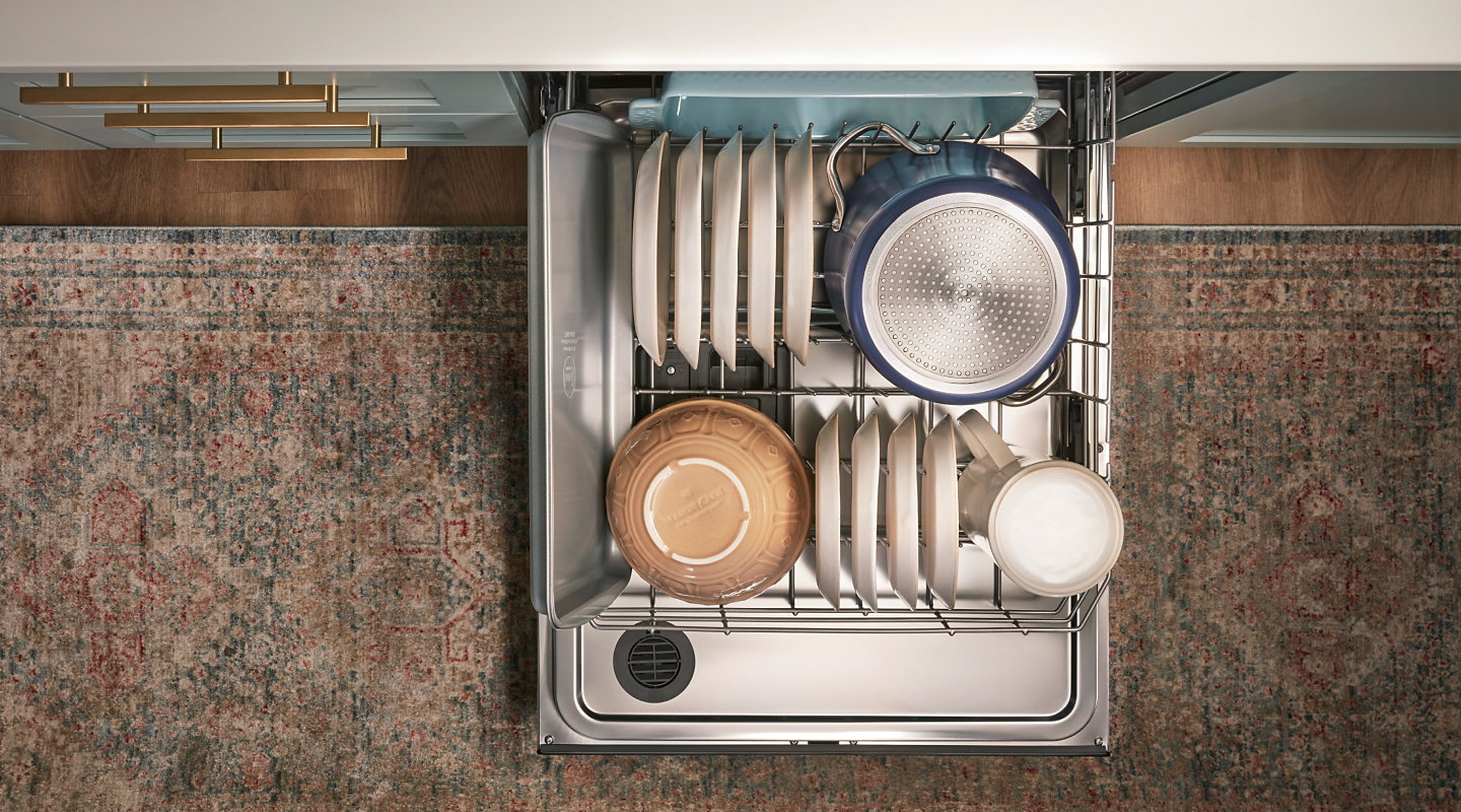 A top view of an open Whirlpool® dishwasher loaded with dishes.