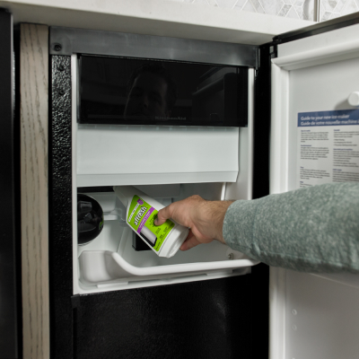 Person pouring affresh® ice machine cleaner into an icemaker