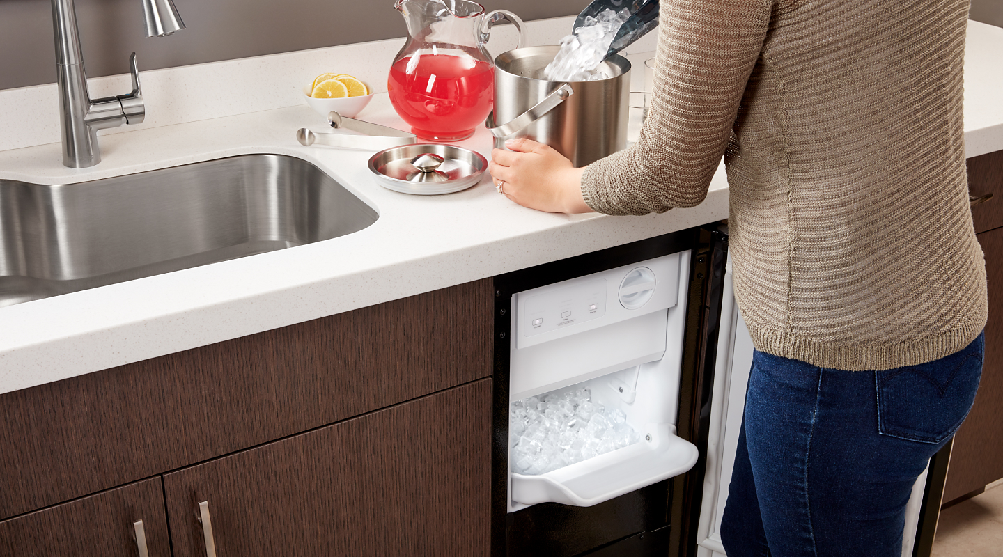 Person filling an ice bucket from a Whirlpool® icemaker