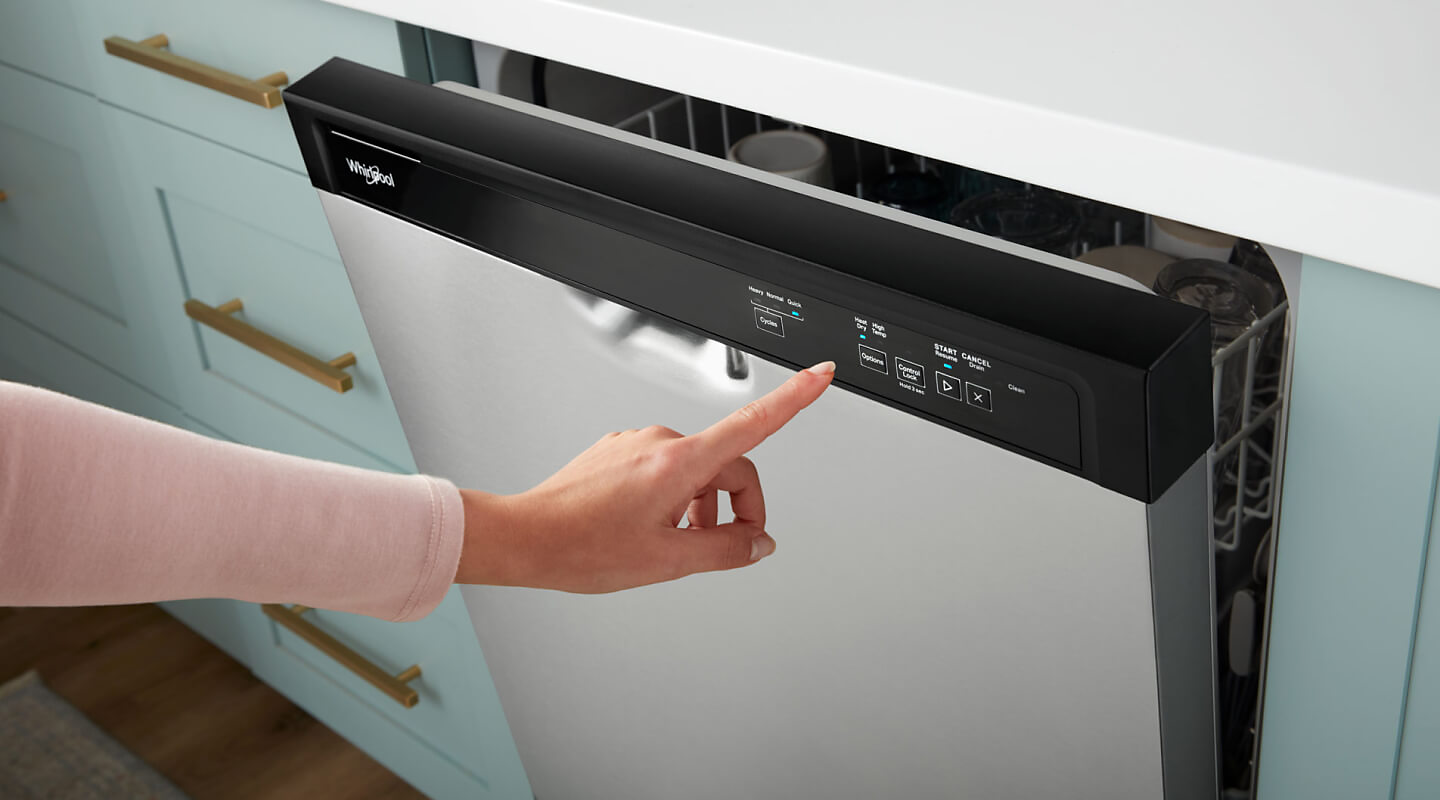 Person selecting settings on front control panel of a Whirlpool brand dishwasher