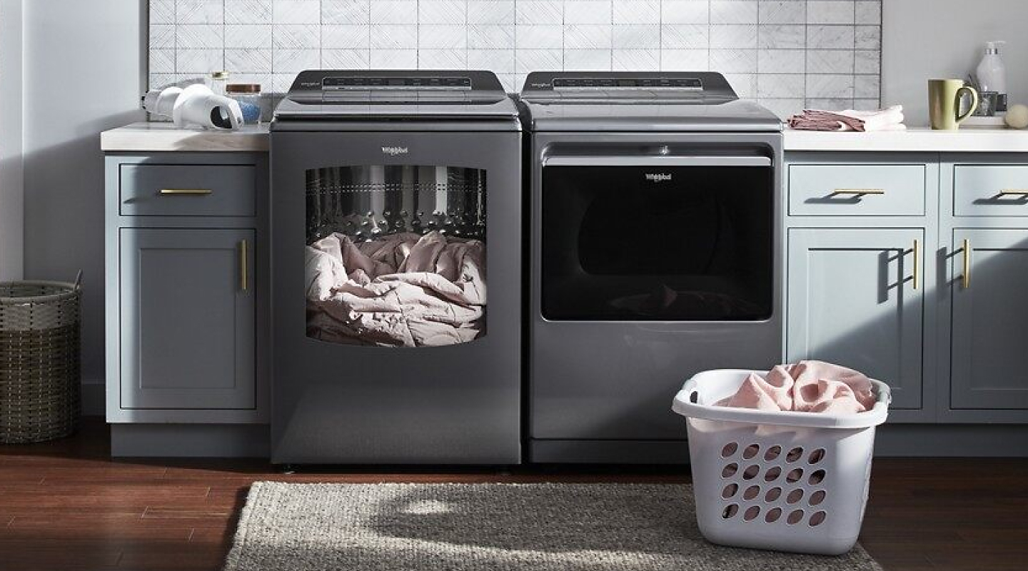 Gray top-load WhirlpoolⓇ laundry pair with comforter in washer.