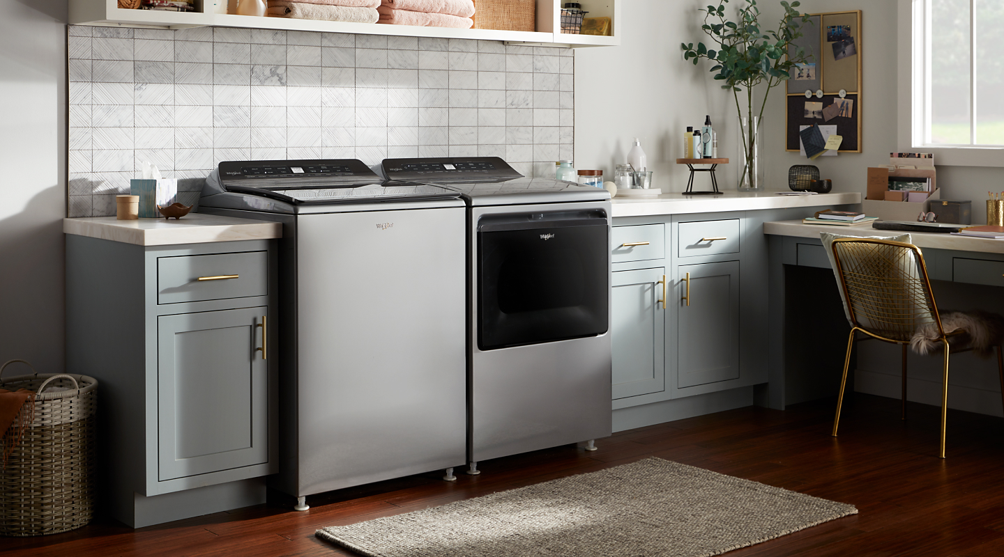 Whirlpool® top load washing machine and dryer in a rustic laundry room
