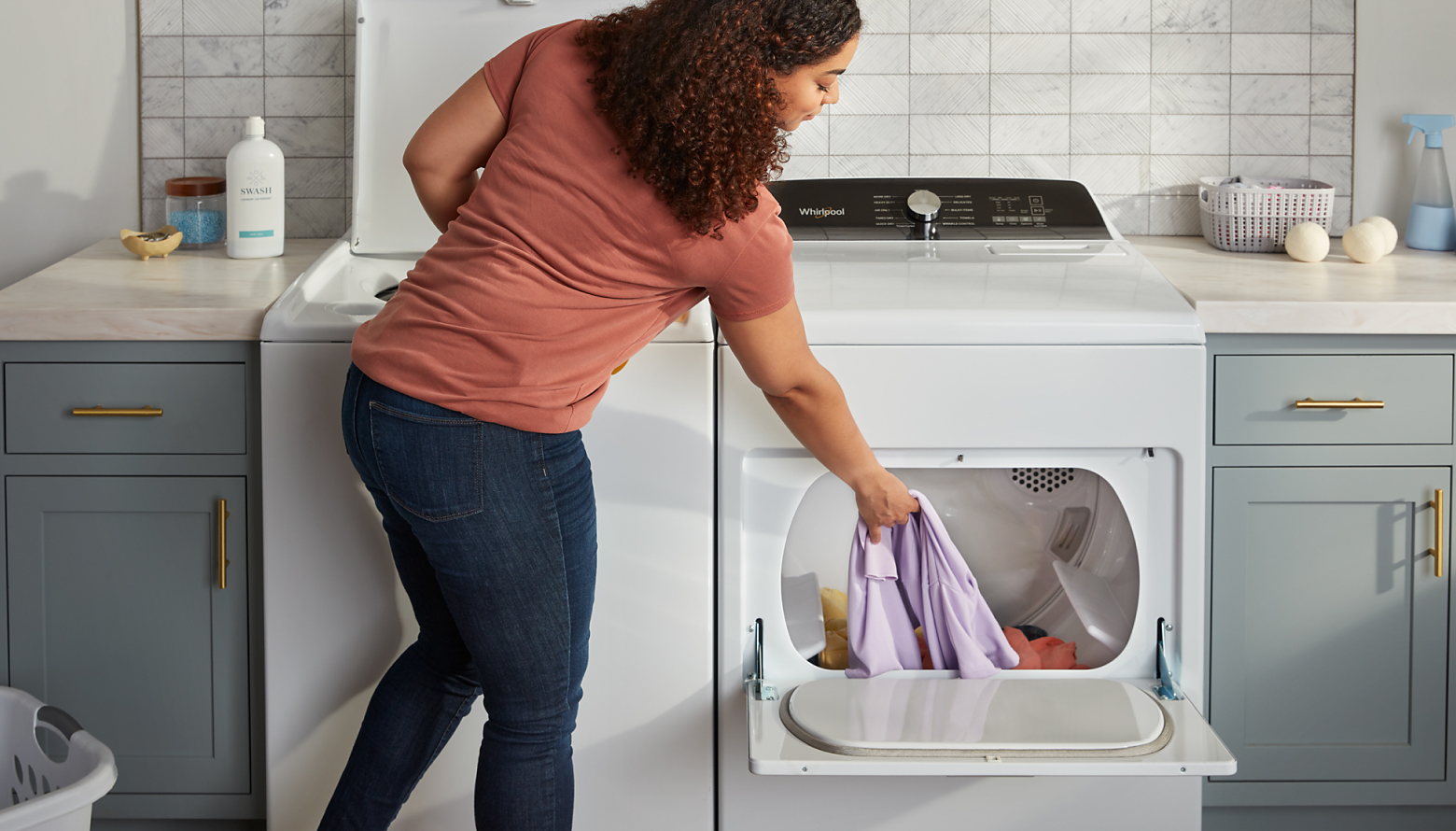 A woman pulling clothes from the dryer