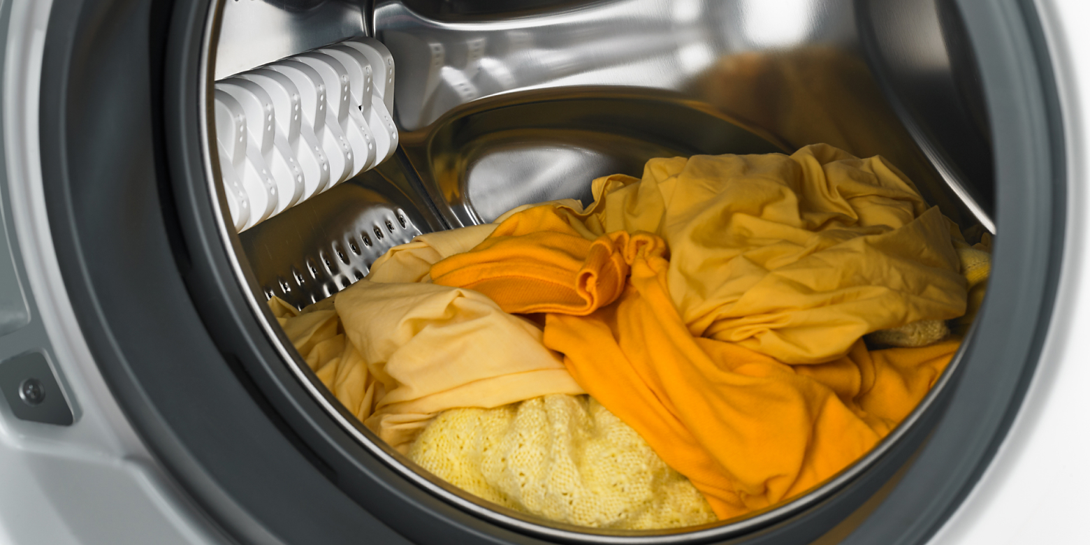 Yellow and orange laundry in a dryer.