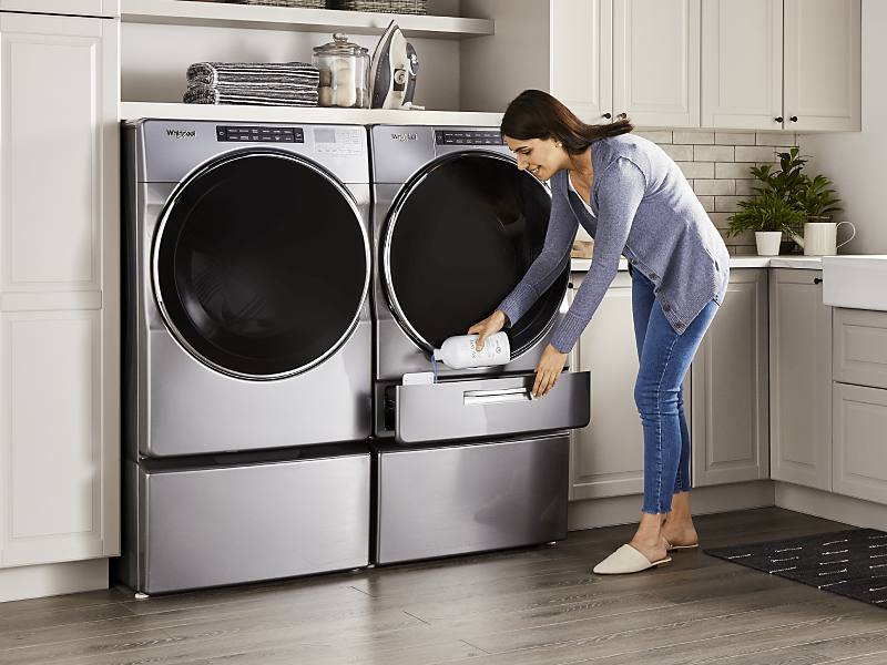 A woman pouring Swash® laundry detergent into a Whirlpool brand washing machine
