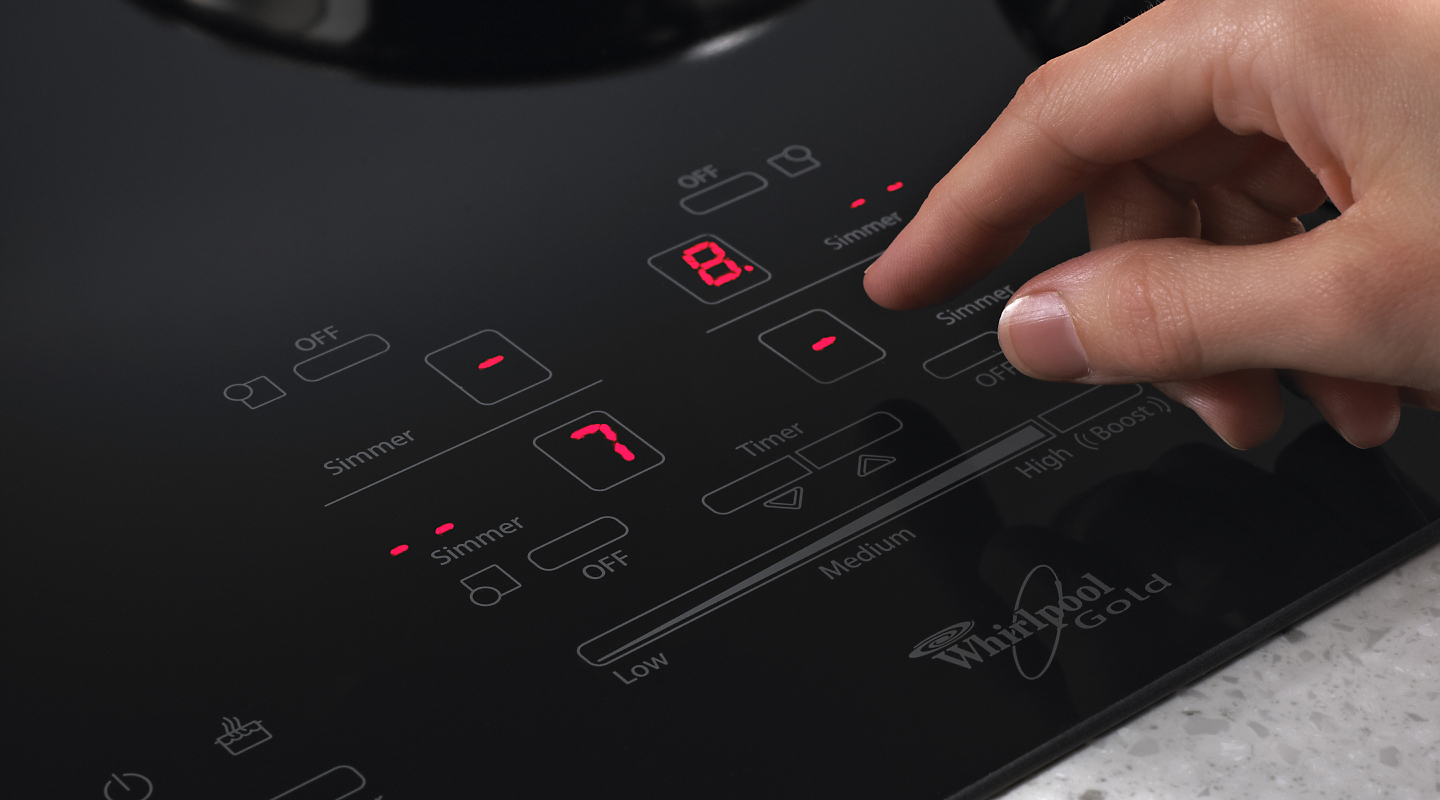 Person selecting settings on an induction cooktop