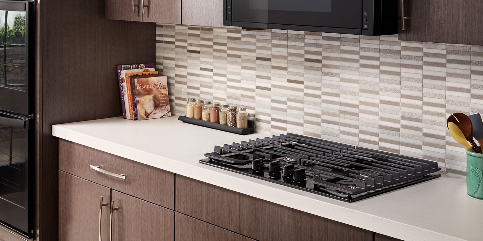 A gas cooktop on a white counter.