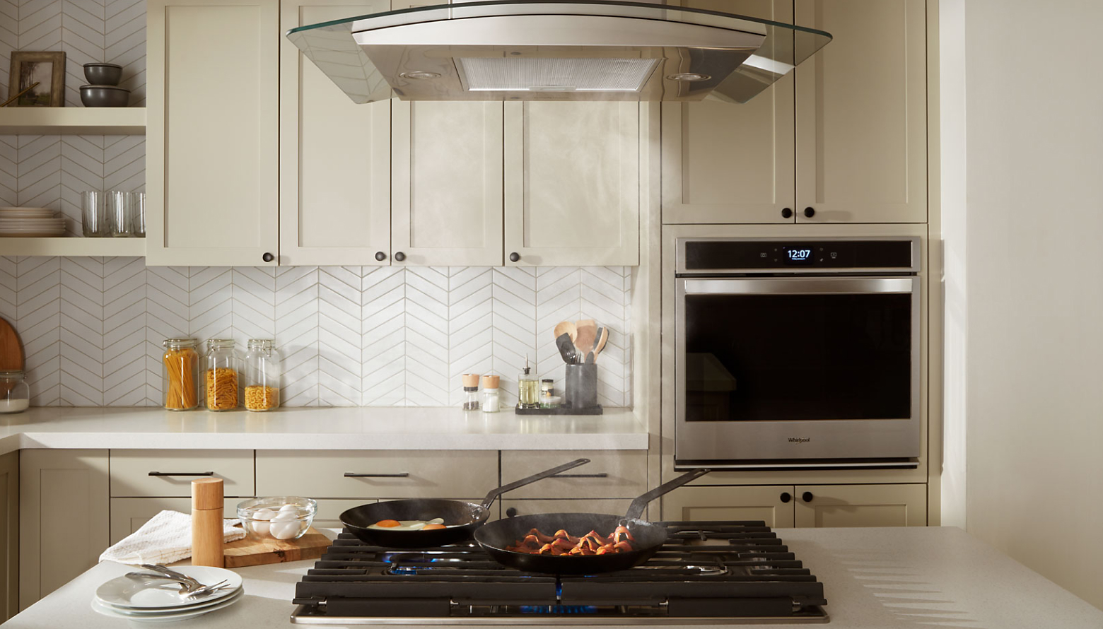 Bacon and eggs sizzling on a gas cooktop.