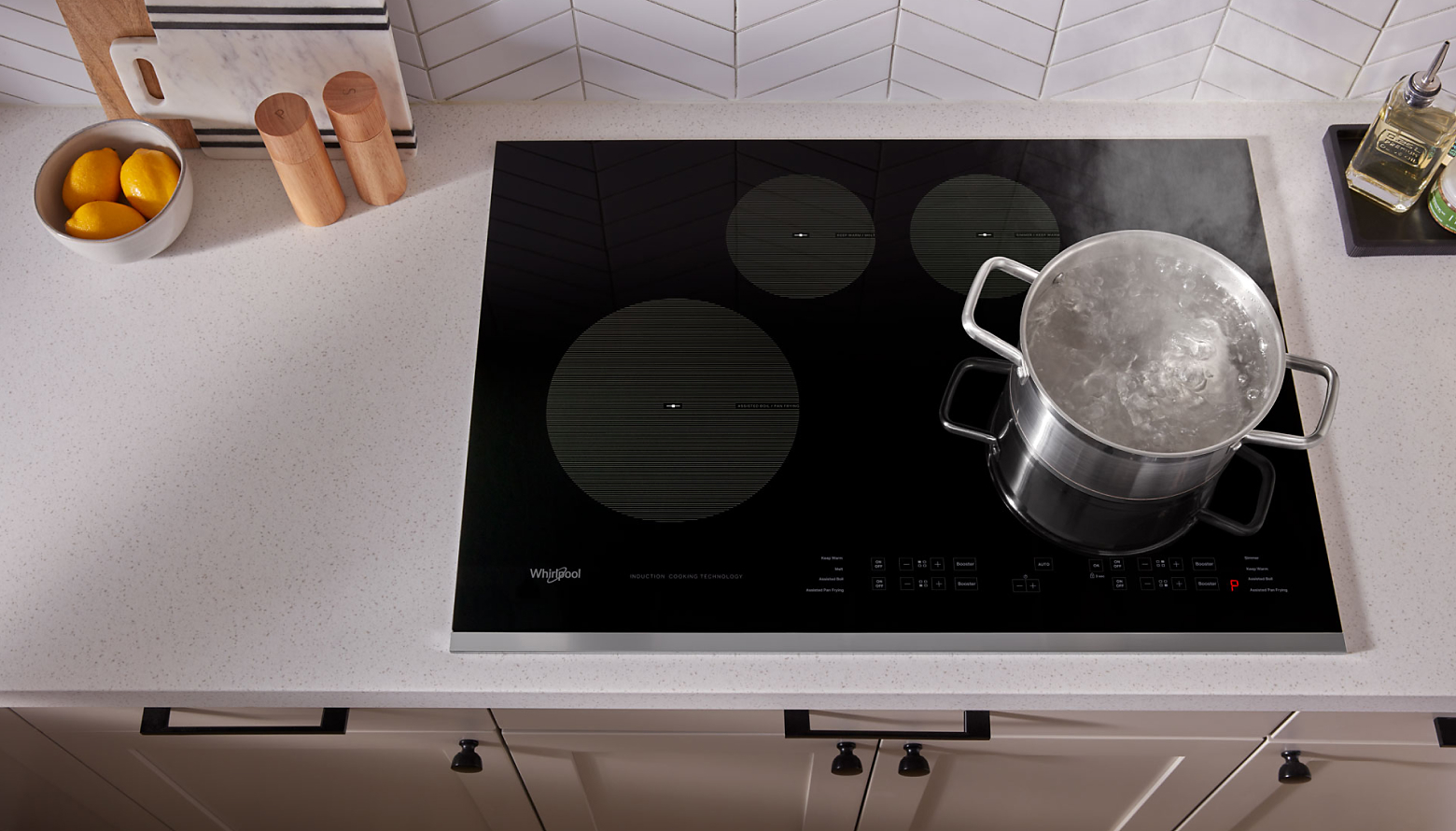 A pot boiling on a black Whirlpool® cooktop.