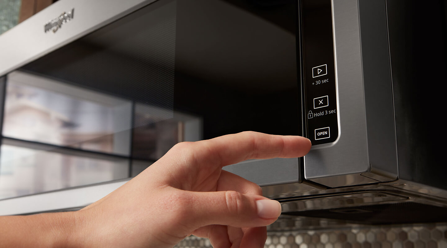 Person selecting a cook setting on a Whirlpool® microwave