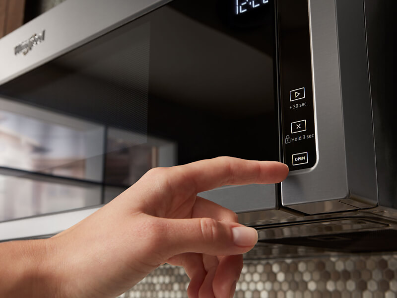 Person selecting a cook setting on a Whirlpool® microwave