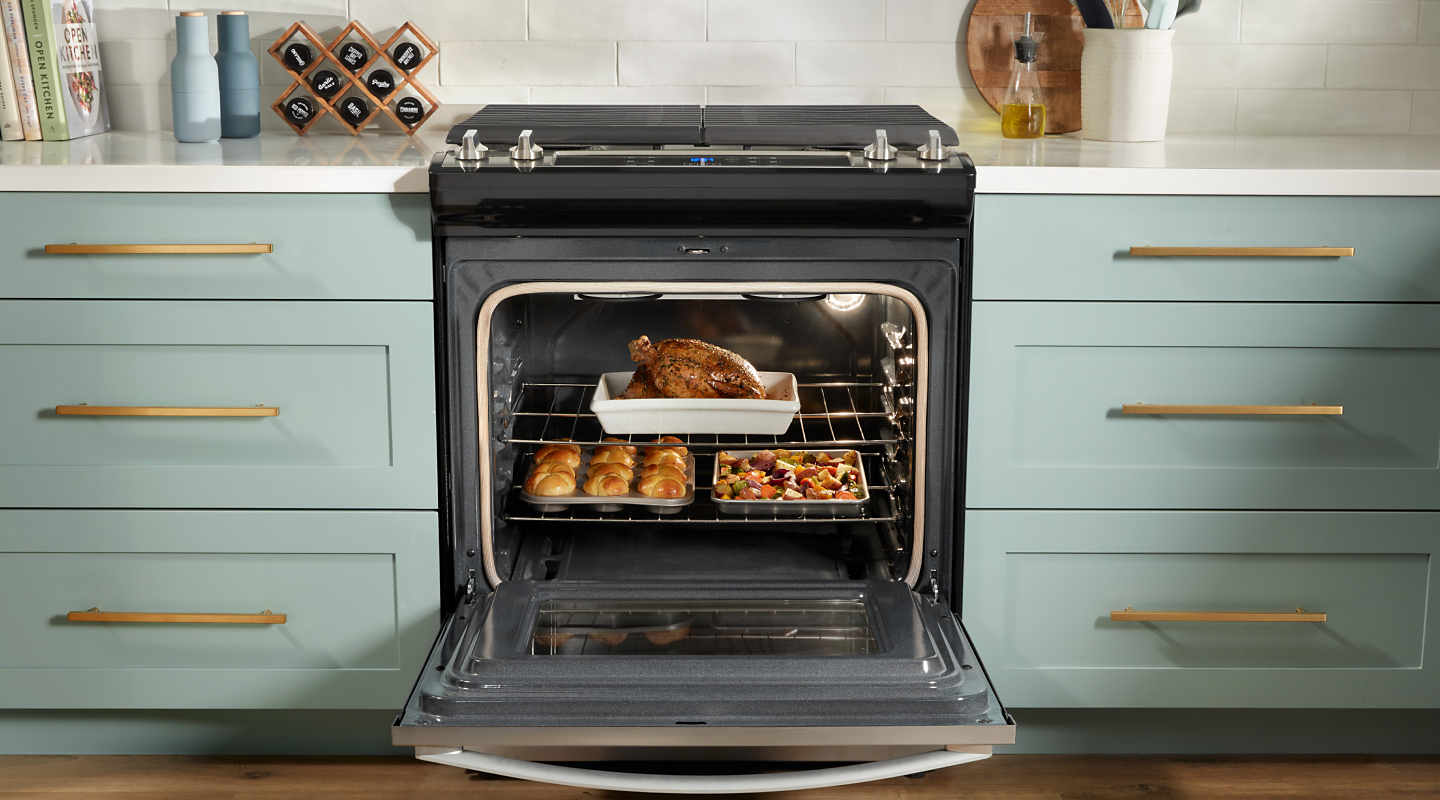 Whirlpool® oven open to show food on multiple racks