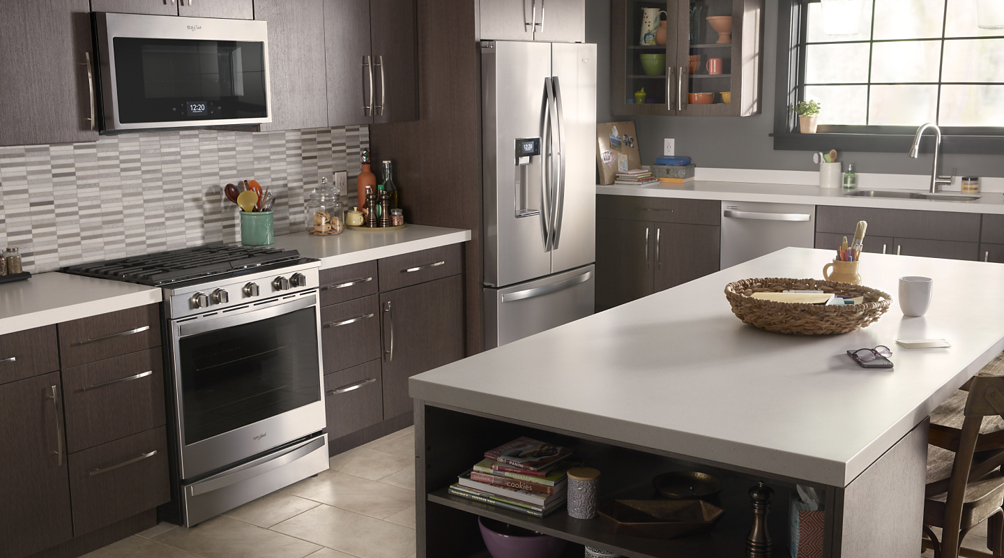 A Whirlpool® oven, over-the-range microwave, refrigerator and dishwasher in a modern kitchen.