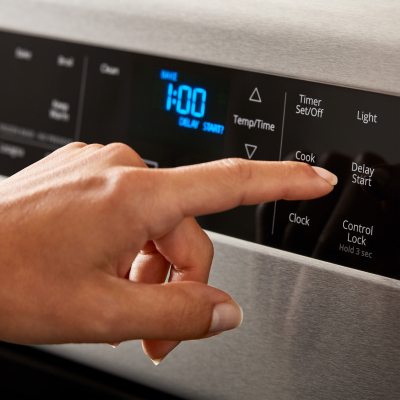 Person selecting a cook setting on a Whirlpool® range