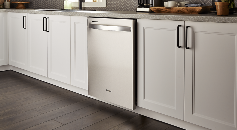 A smart Whirlpool® Dishwasher set in white cabinets