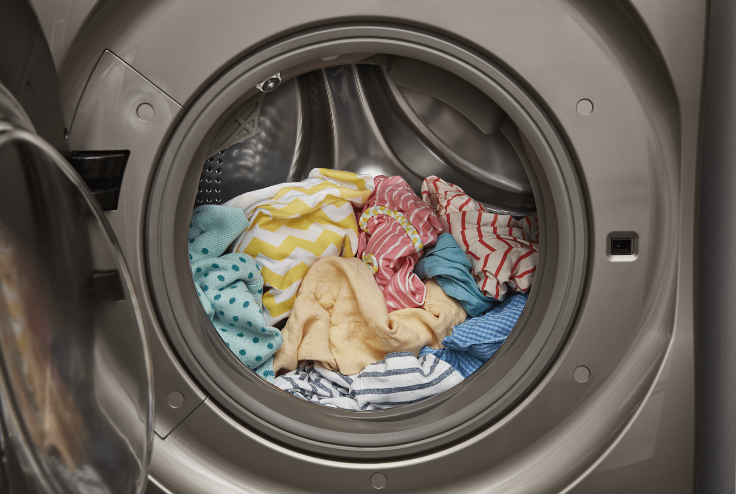 An open front load washer with a load of laundry inside