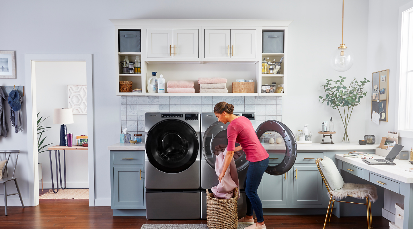 Person loading laundry into a Whirlpool® dryer
