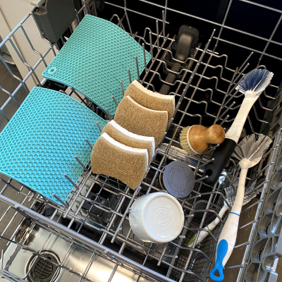 A variety of items being washed on the top shelf of a dishwasher