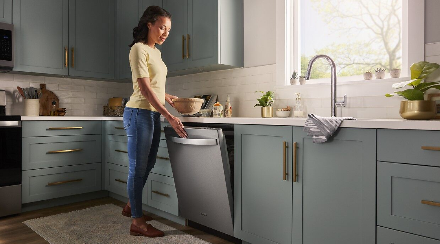 Woman opening a Whirlpool® top control dishwasher