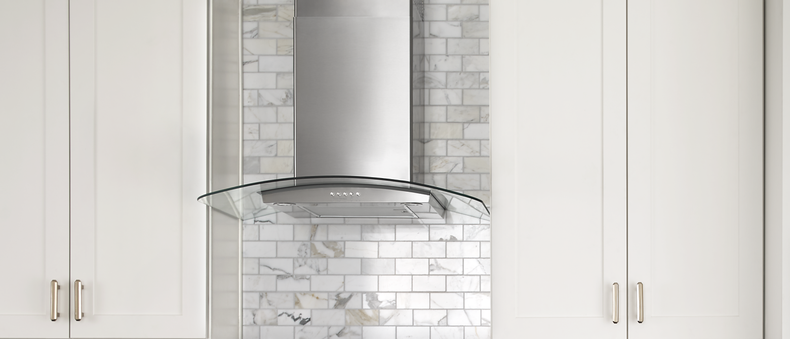 Glass-edged wall-mounted canopy hood between cabinets