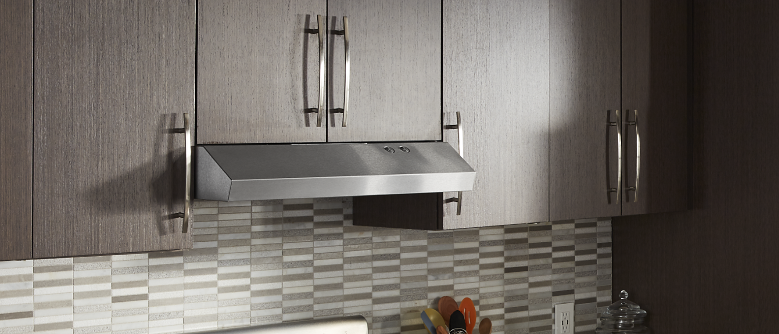 Undercabinet hood installed beneath modern wood cabinets