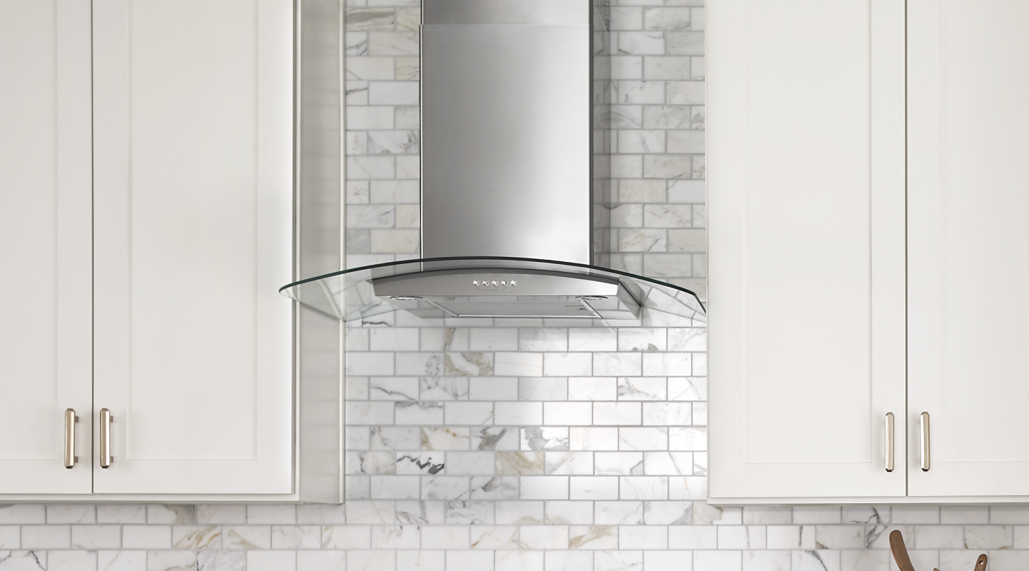Glass-edged wall-mounted canopy hood between cabinets
