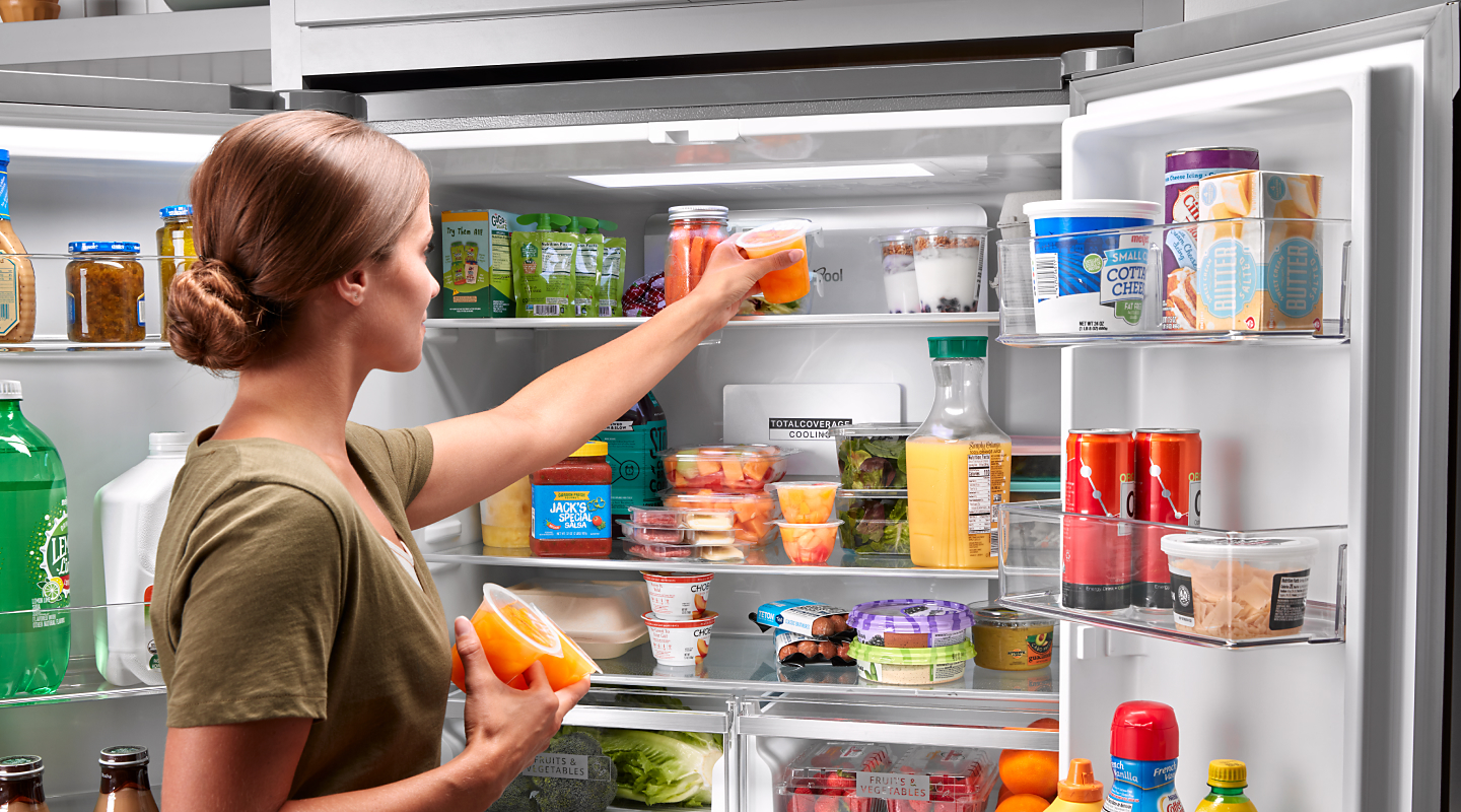 Person placing items on top shelf of Whirlpool® refrigerator