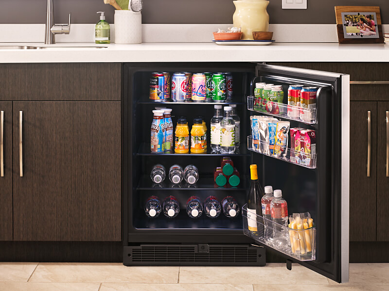  Fully stocked open undercounter refrigerator in a kitchen