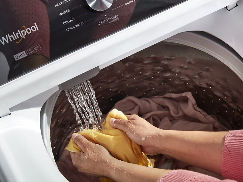 A person soaking clothes in a Whirlpool® washer