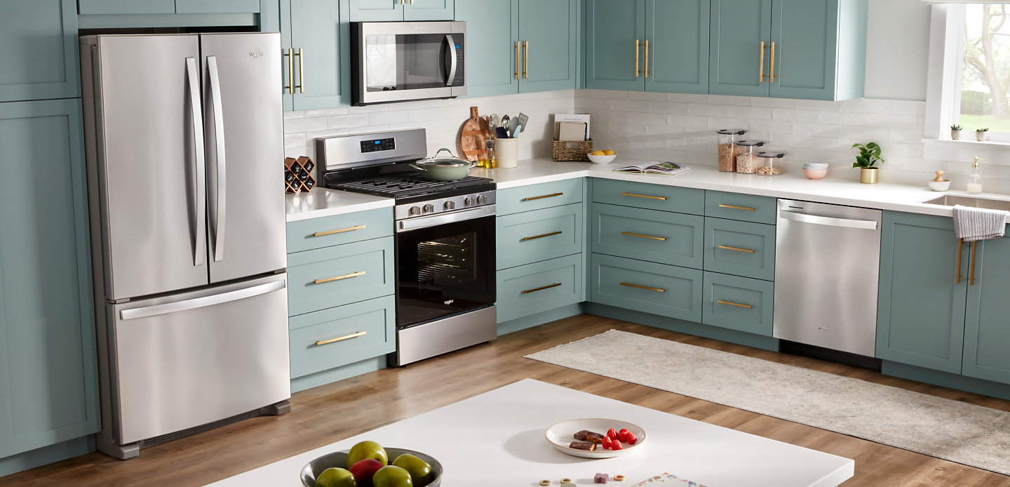 Stainless steel Whirlpool® appliances in a teal painted kitchen