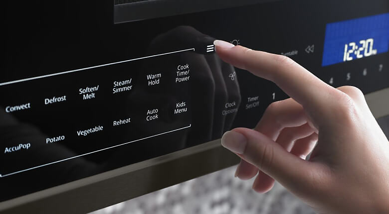 Hand pressing buttons on microwave control panel
