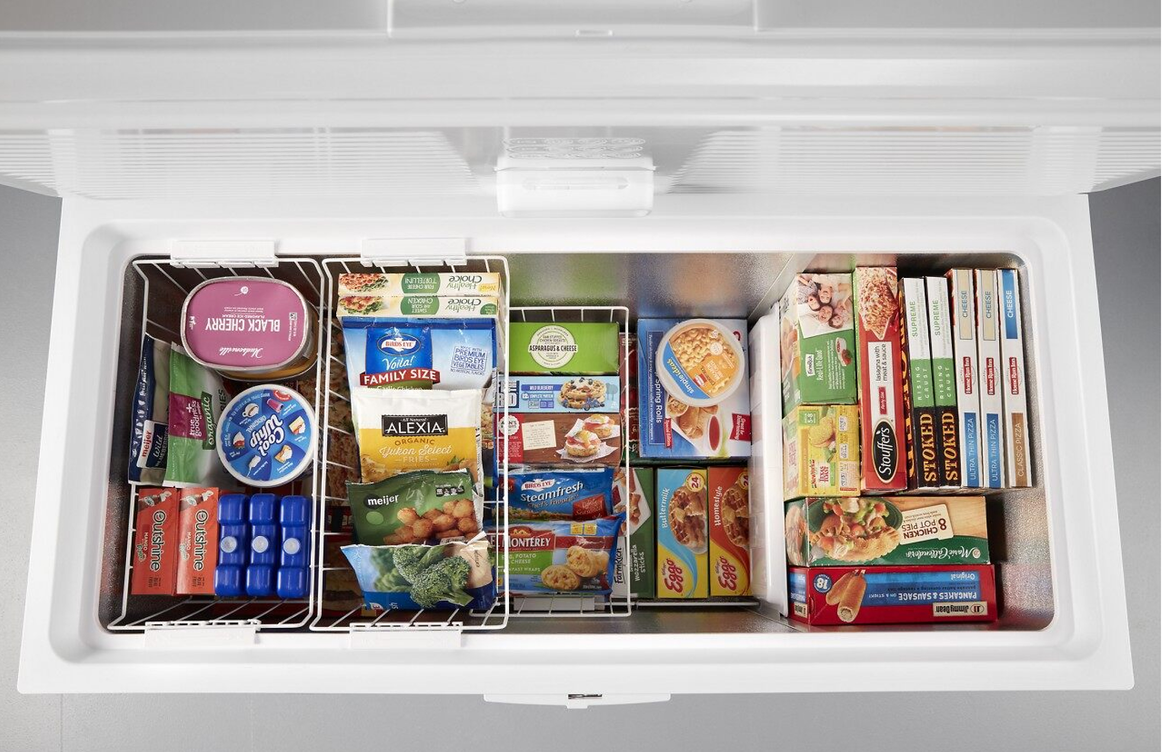 Overhead view of a Whirlpool® deep freezer with frozen food in bins