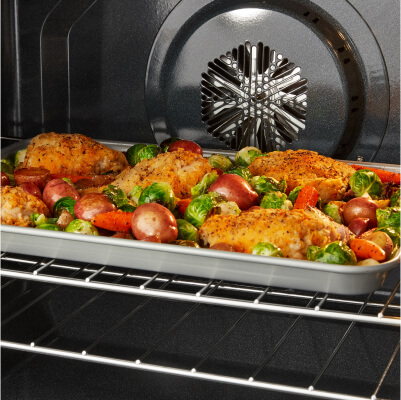 Food cooking on a sheet pan in the oven