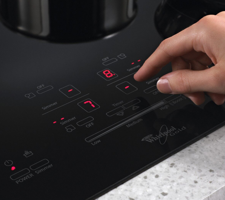 Hand choosing settings on induction cooktop