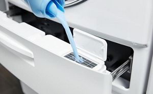 Liquid fabric softener being added to a washing machine dispenser